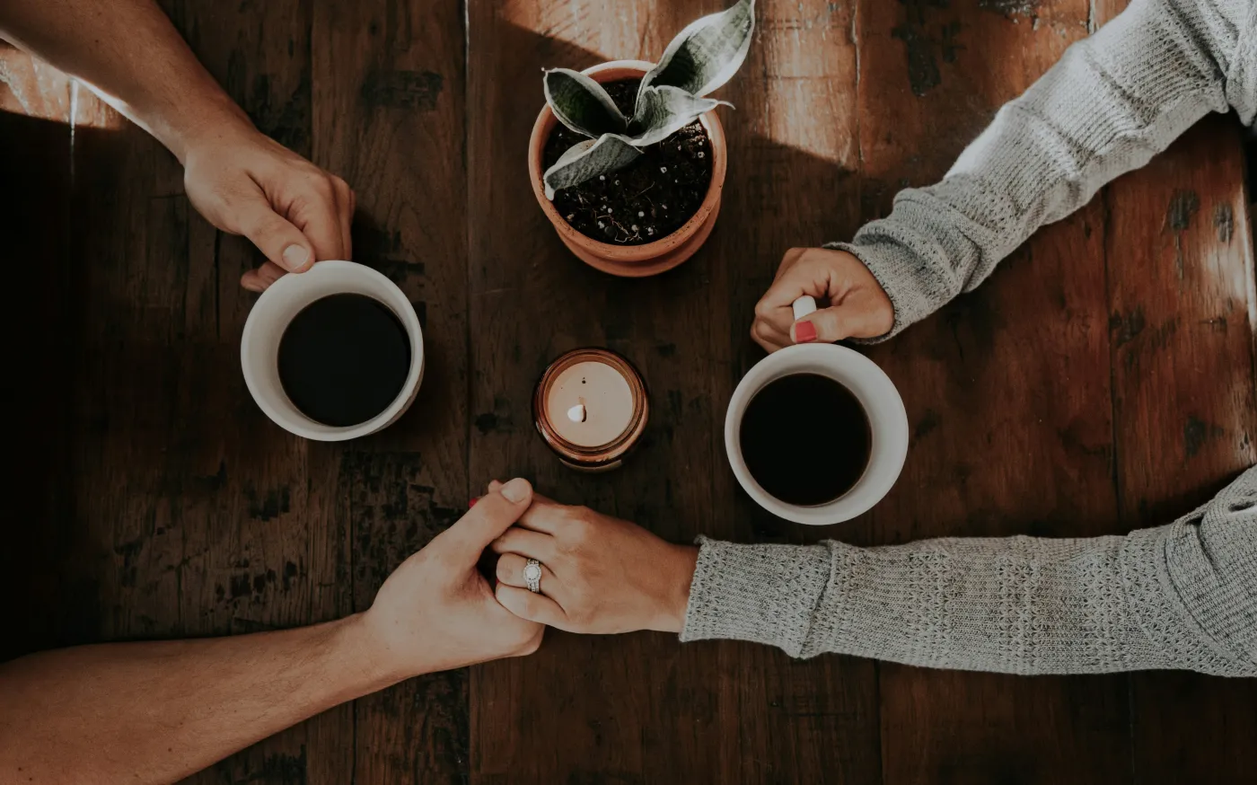 person holding white ceramic mugs by taylor hernandez courtesy of Unsplash.