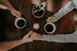 person holding white ceramic mugs by taylor hernandez courtesy of Unsplash.