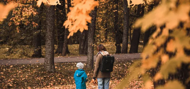 A man and a child walking through a park by E I courtesy of Unsplash.